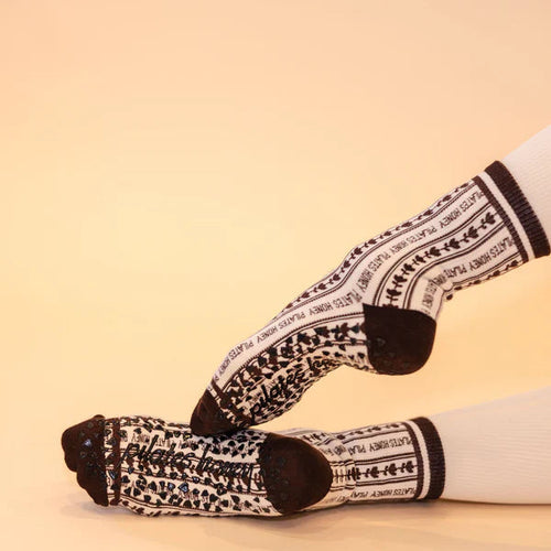 White socks with black pattern worn on a beige background