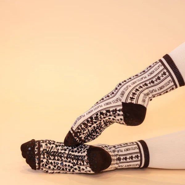 White socks with black pattern worn on a beige background