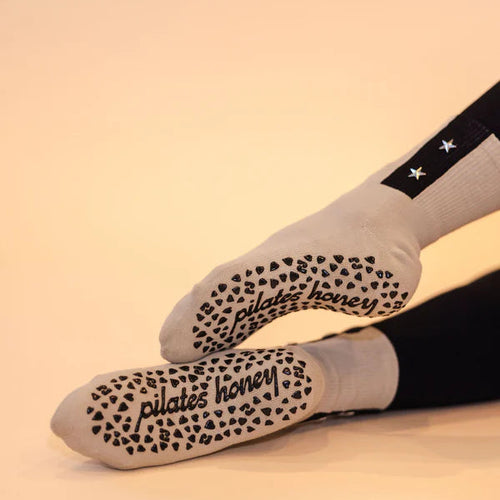 Pair ofg reen socks with black text and patterns on a beige background