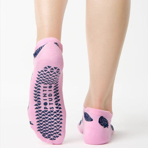 Pink socks with blue patterns worn by a person on a white background