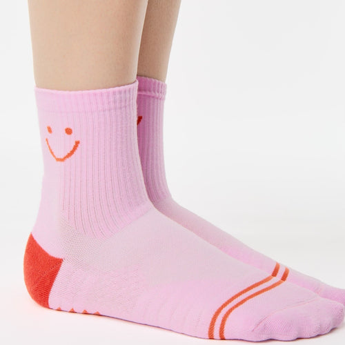 Pink socks with a smiley face design on a white background