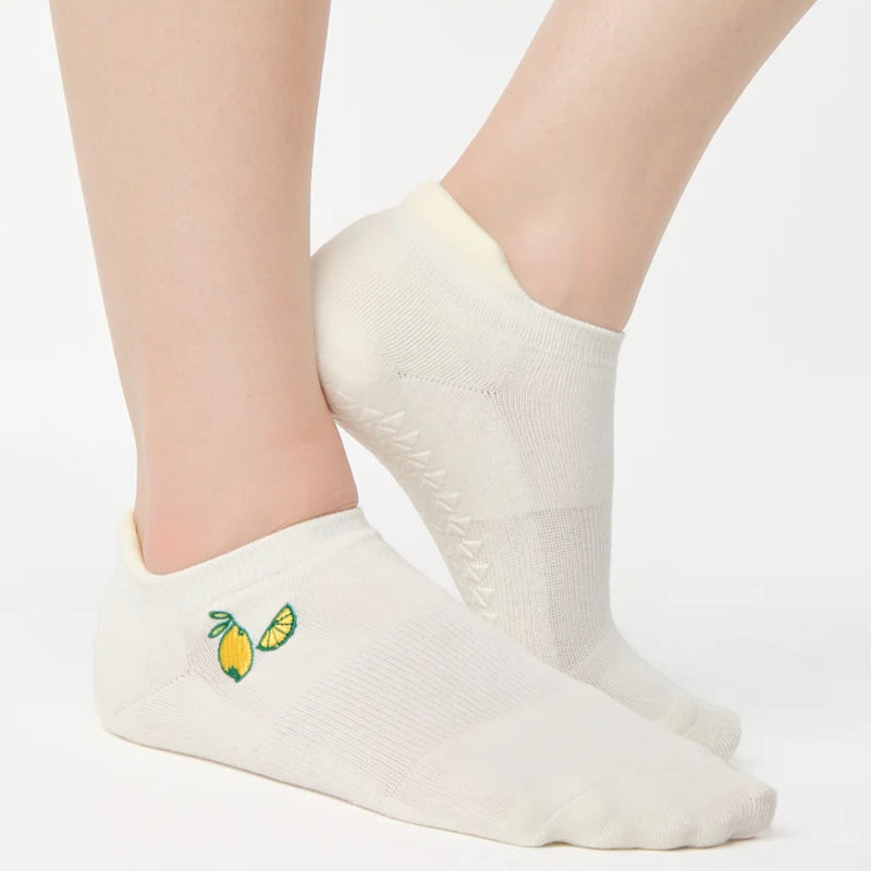 White socks with lemon designs on a plain background