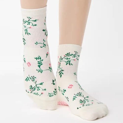 White socks with floral patterns worn by a person on a white background
