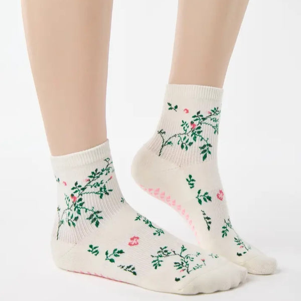 White socks with floral patterns worn by a person on a white background