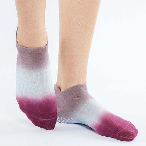 Purple and white gradient ankle socks worn by a person on a white background