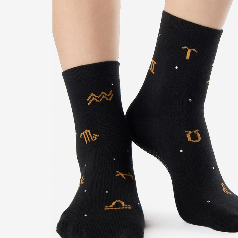Black socks with gold zodiac symbols on a white background