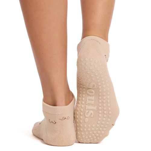 Beige socks with textured sole and brand name on a white background
