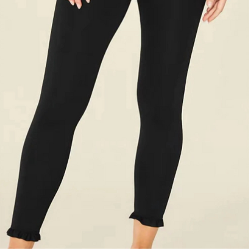 Black leggings worn by a person on a beige background