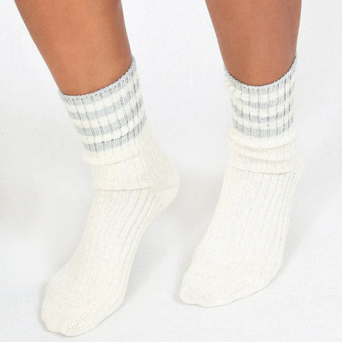 White socks with gray stripes worn by a person on a white background