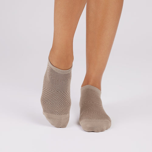 Beige ankle socks worn by a person on a white background