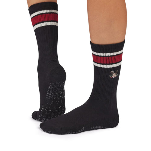 Black socks with red and white stripes worn by a person on a white background
