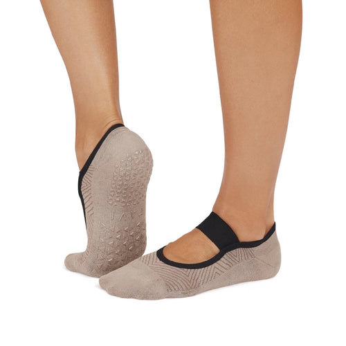 Beige socks with black bands worn on feet against a white background