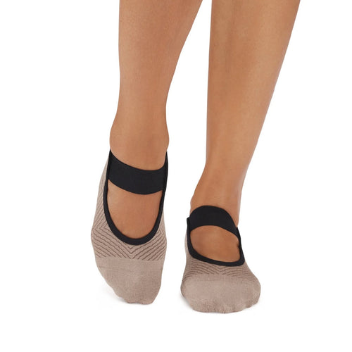 Beige socks with black bands worn by a person on a white background