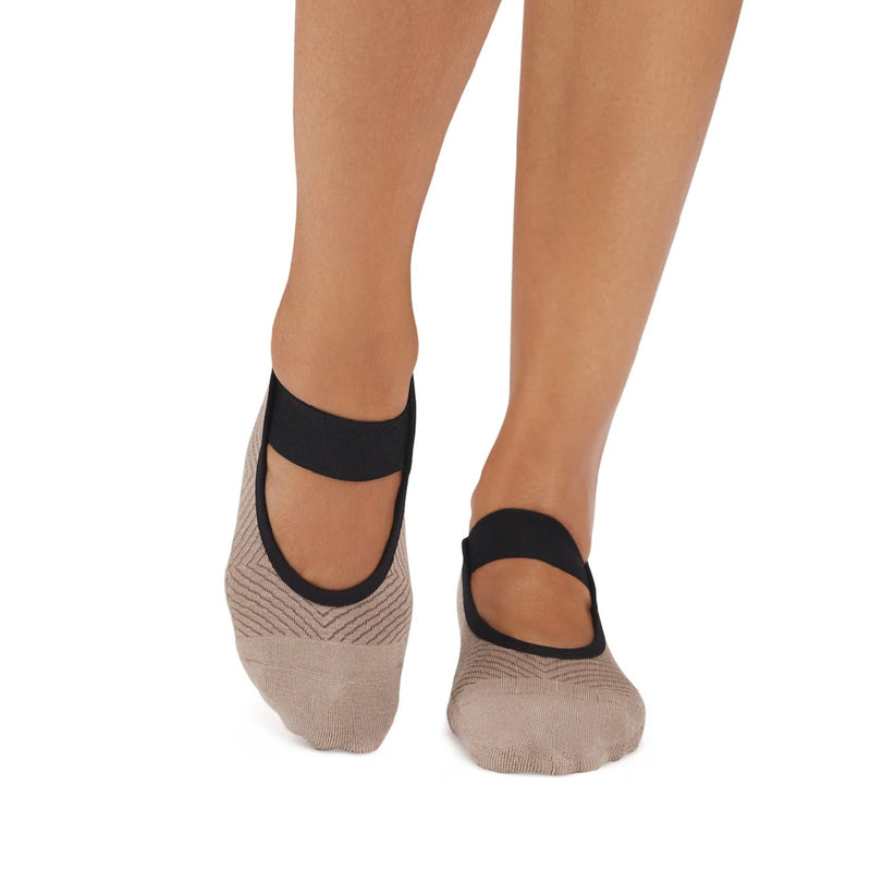 Beige socks with black bands worn by a person on a white background