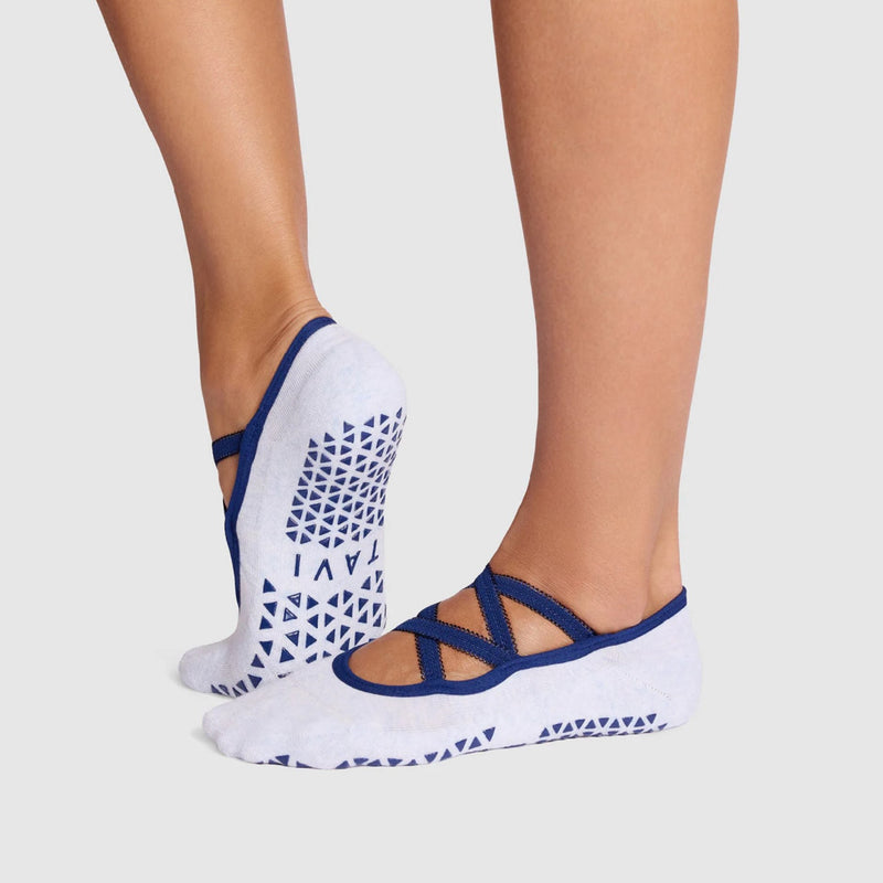 White socks with blue geometric patterns worn by a person on a light gray background