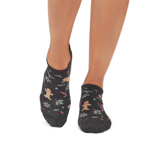 Black ankle socks with gingerbread man design worn by a person on a white background