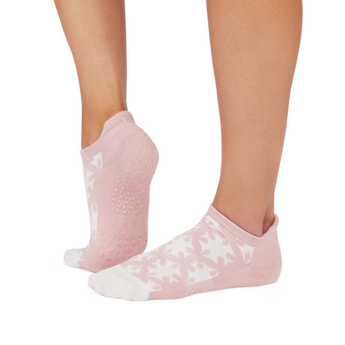 Pink socks with white patterns worn by a person on a white background