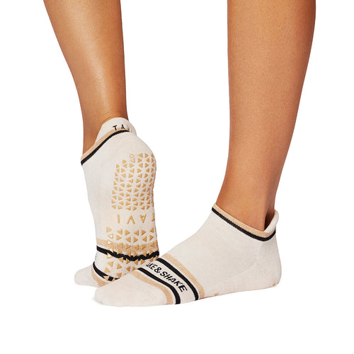 White socks with black and gold accents worn by a person on a white background