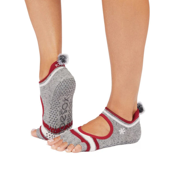 Gray and red toe-separated socks with pom-poms worn by a person on a white background