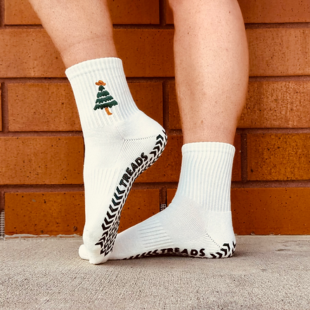 White socks with black and white patterns worn by a person against a brick wall.