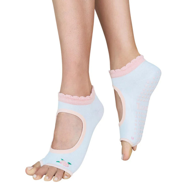 A pair of open-toe ankle socks worn on feet, shown against a plain white background. The socks are light blue with pink trim, scalloped edges, and grip dots on the sole, featuring a small embroidered flamingo design on one sock.